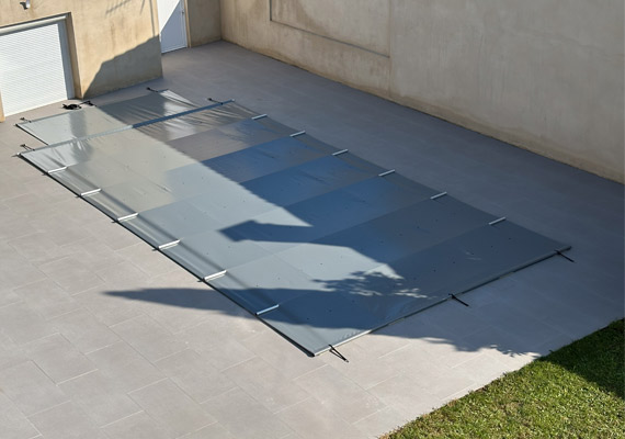 La couverture de sécurité pour piscine Notos de fond parfaitement dans l'environnement de votre jardin